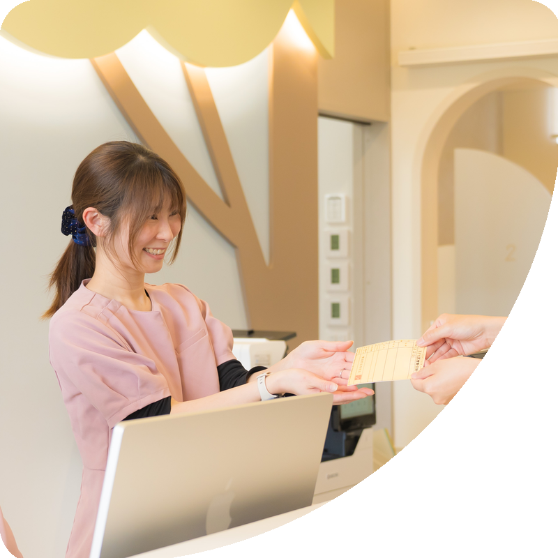 受付で診察券を受け取るスタッフ