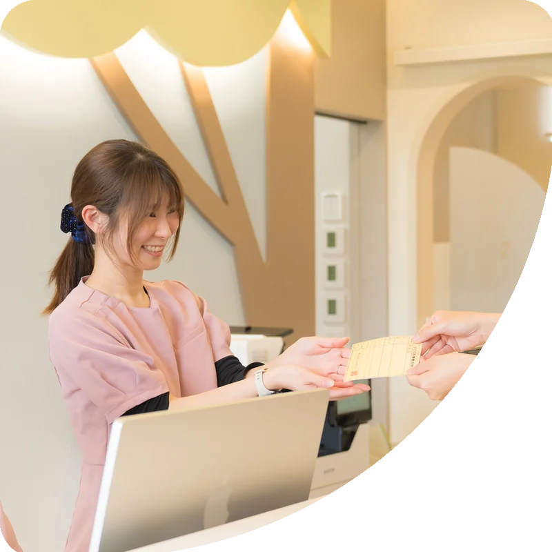 受付で診察券を受け取るスタッフ